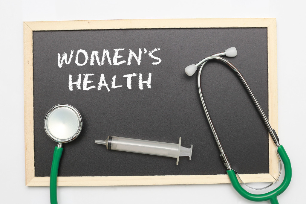 WOMEN'S HEALTH concept with stethoscope and syringe